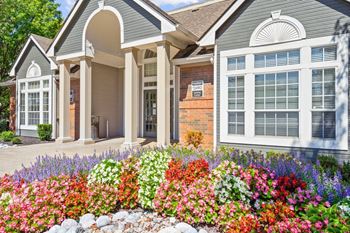 The clubhouse and leasing office with a gorgeous flower bed at Stonebriar Apartments in Overland Park, KS.